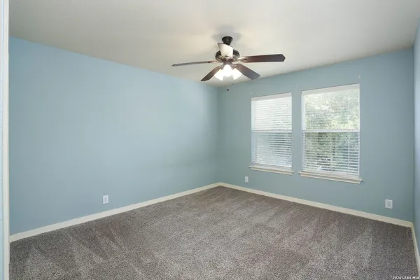 an empty room with a window and a fan