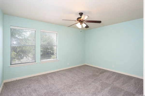 an empty room with a window and a fan