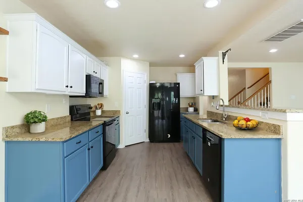 a kitchen with a sink a refrigerator and wooden cabinets