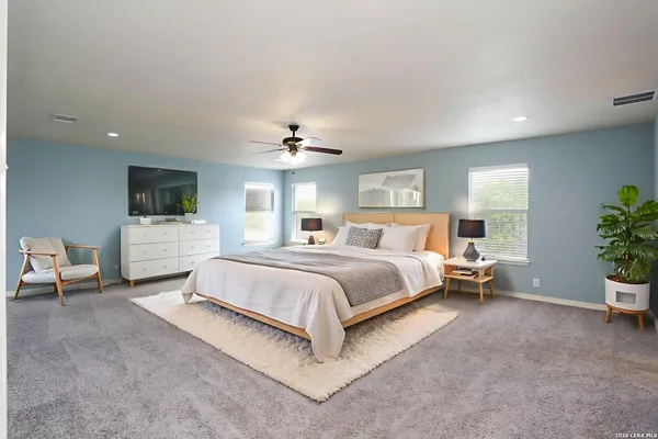 a spacious bedroom with a bed and a couch