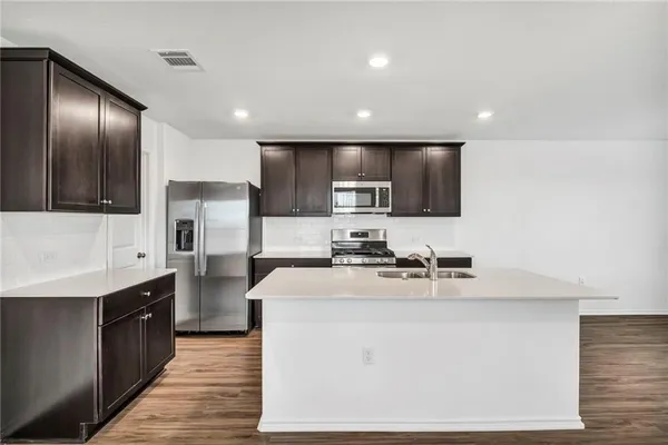 a kitchen with stainless steel appliances granite countertop a sink stove and refrigerator