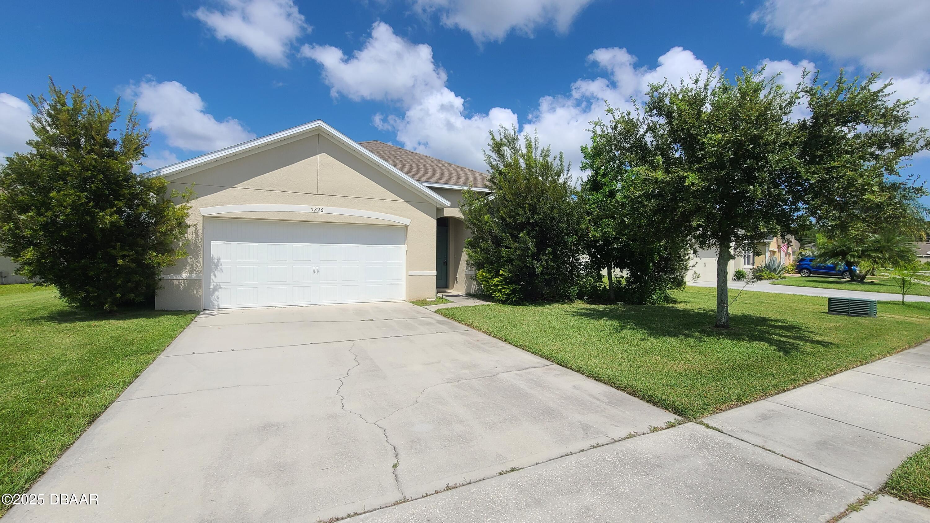 5296 Bear Corn Run Port Orange, FL 32128 - Photo 1 of 31 a view of a white house next to a yard with big trees