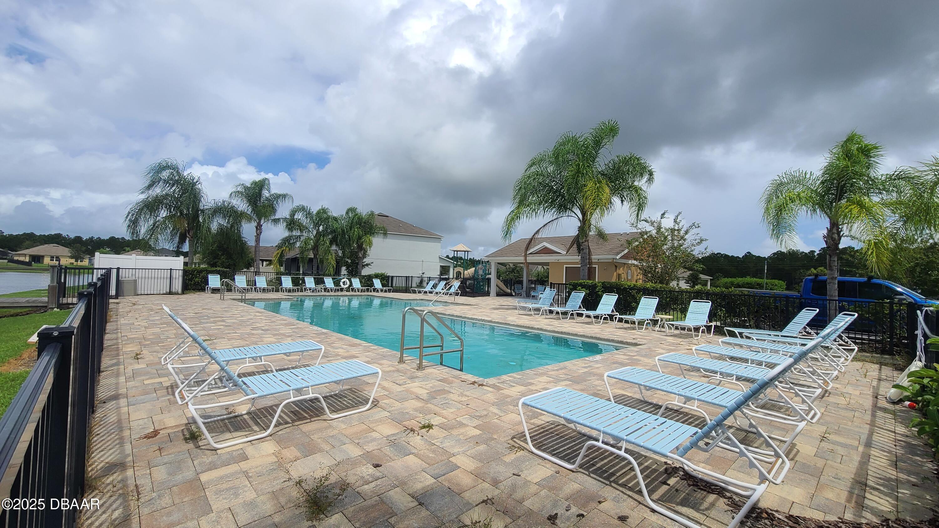 5296 Bear Corn Run Port Orange, FL 32128 - Photo 31 of 31 a view of a swimming pool with a lounge chairs