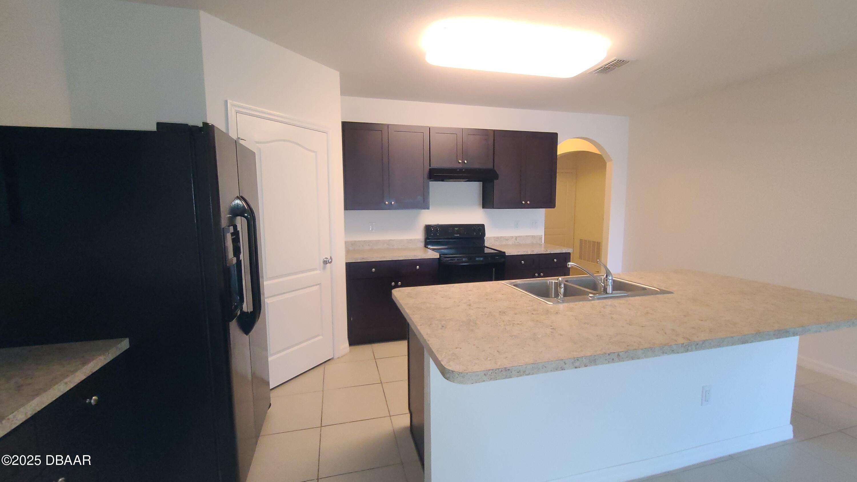 5296 Bear Corn Run Port Orange, FL 32128 - Photo 6 of 31 a kitchen with granite countertop a refrigerator and a sink