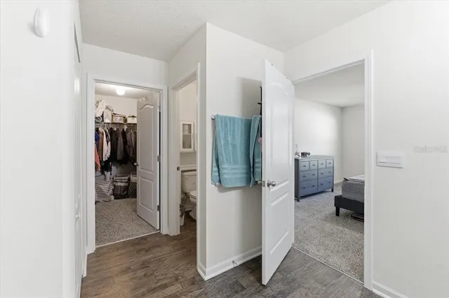 a view of a hallway with wooden floor and living room
