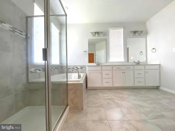 a bathroom with a tub sink and mirror