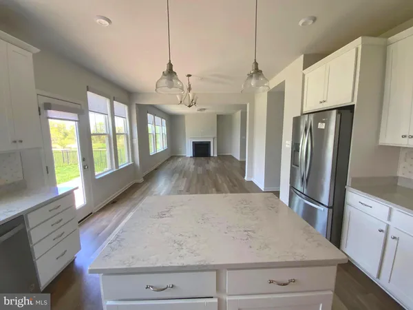 a kitchen with stainless steel appliances granite countertop a refrigerator a stove and a sink with wooden floor