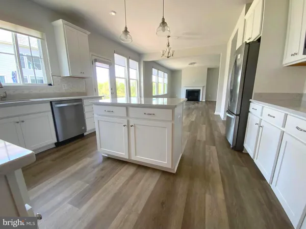 a kitchen with stainless steel appliances a refrigerator sink and wooden floor