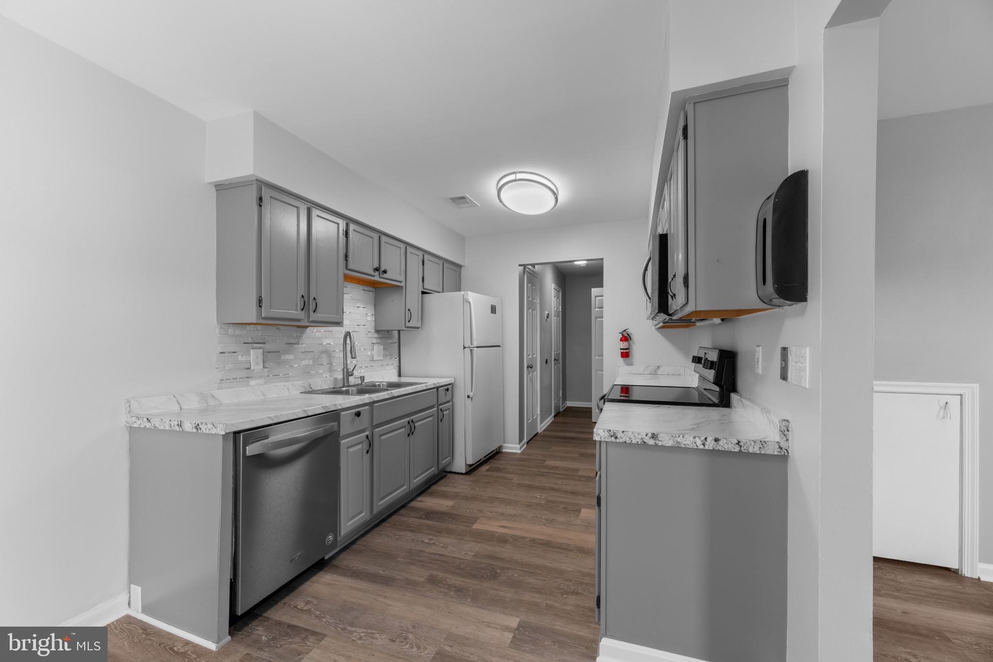 9302 Player Drive, Unit 155 Laurel, MD 20708 - Photo 11 of 43 a kitchen with stainless steel appliances granite countertop a sink stove and refrigerator