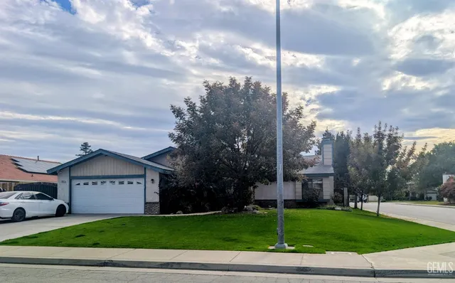 a view of a house with a big yard and large trees