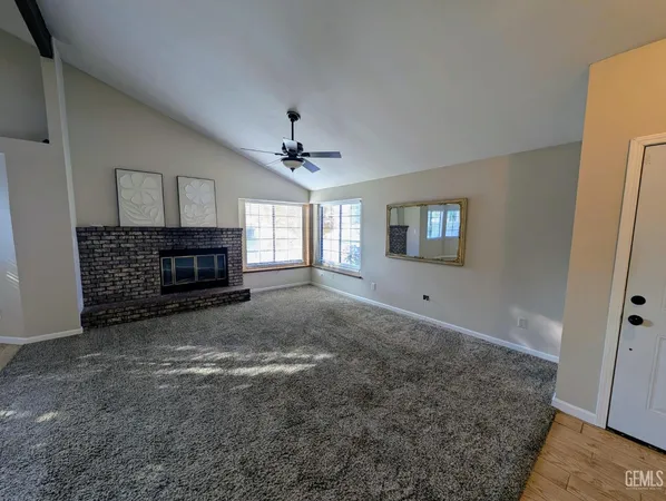 a view of an empty room with a fireplace and a window