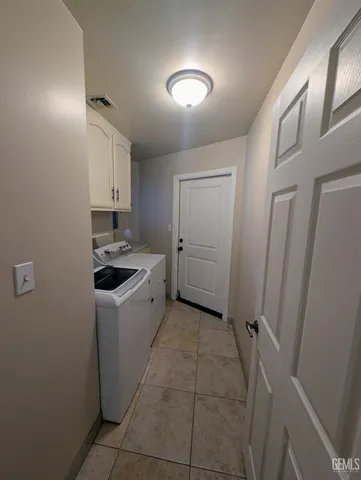 a utility room with cabinets washer and dryer