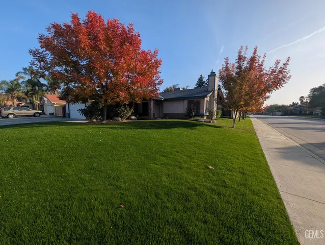 a backyard of a house with lots of green space and fountain