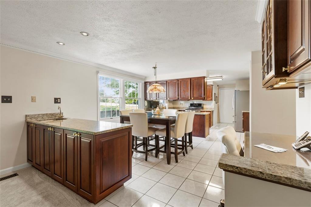99 Walnut Drive McKees Rocks, PA 15136 - Photo 11 of 50 a kitchen with stainless steel appliances granite countertop a table chairs and a refrigerator