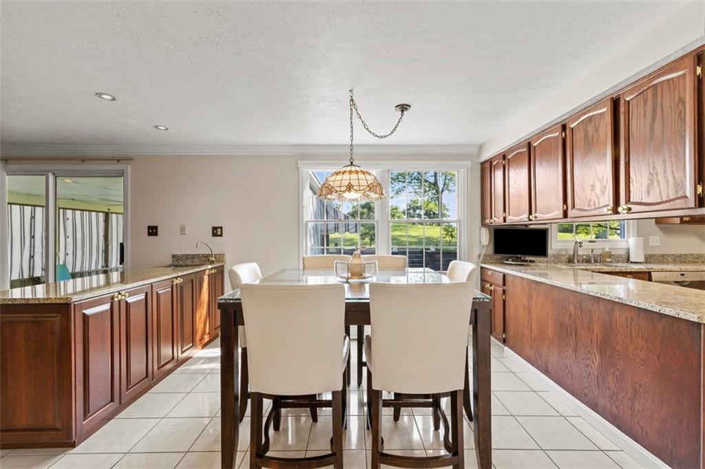 99 Walnut Drive McKees Rocks, PA 15136 - Photo 12 of 50 a kitchen with stainless steel appliances granite countertop a stove a refrigerator a kitchen island with chairs and cabinets