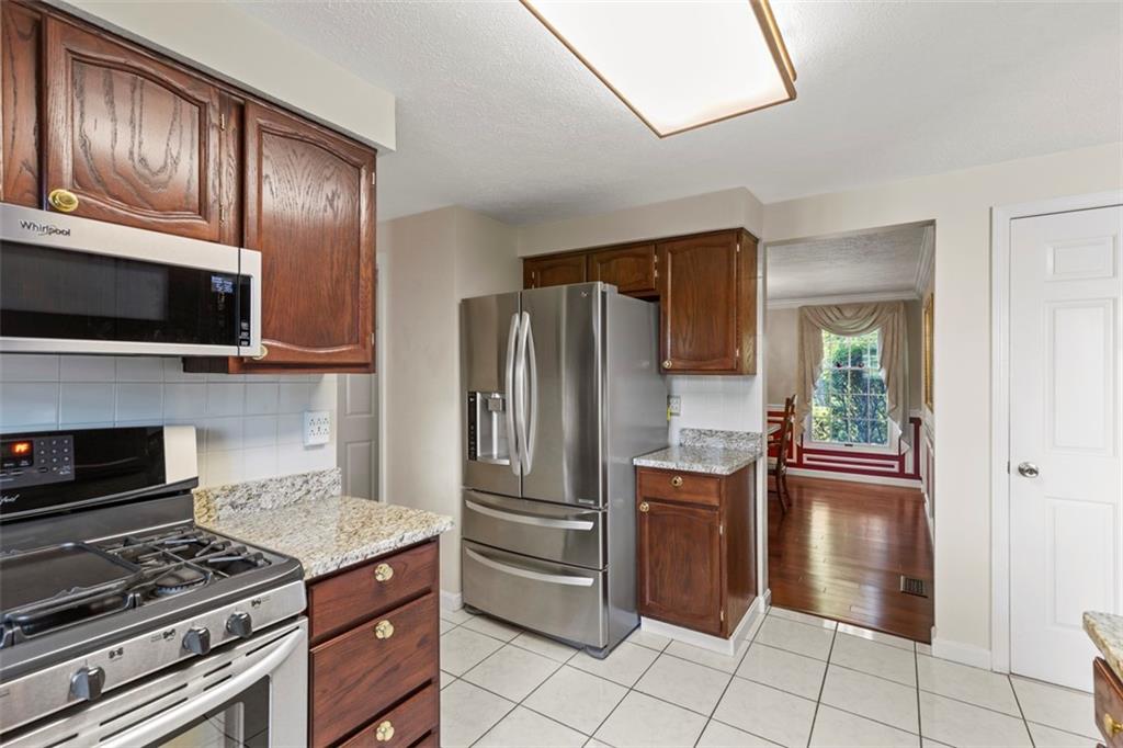 99 Walnut Drive McKees Rocks, PA 15136 - Photo 16 of 50 a kitchen with granite countertop a refrigerator stove and microwave