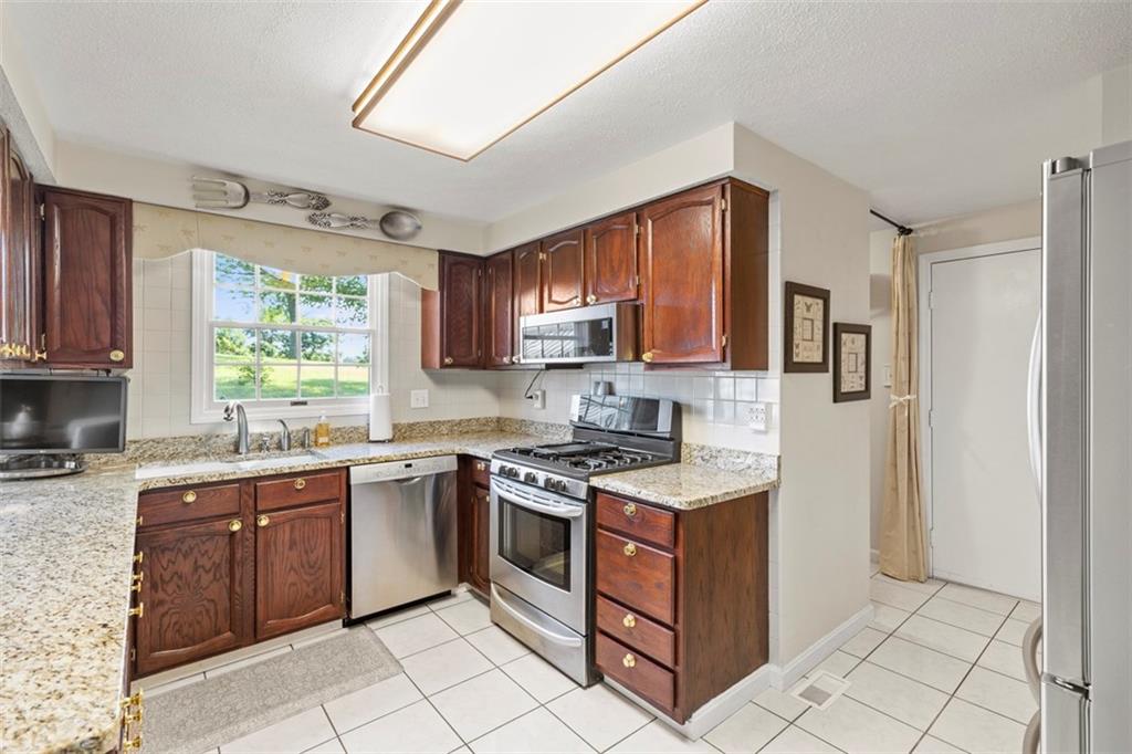 99 Walnut Drive McKees Rocks, PA 15136 - Photo 18 of 50 a kitchen with stainless steel appliances granite countertop a stove a sink dishwasher and a refrigerator