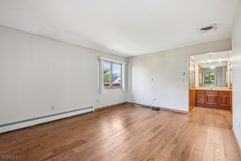 8 Cambridge Road Totowa, NJ 07512 - Photo 13 of 35 an empty room with wooden floor and windows