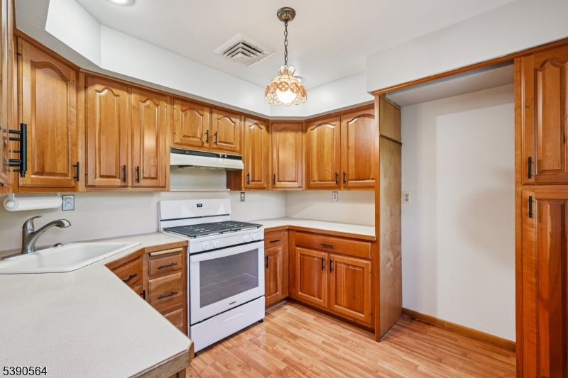 8 Cambridge Road Totowa, NJ 07512 - Photo 23 of 35 a kitchen with stainless steel appliances granite countertop a stove a sink dishwasher and a refrigerator with wooden floor