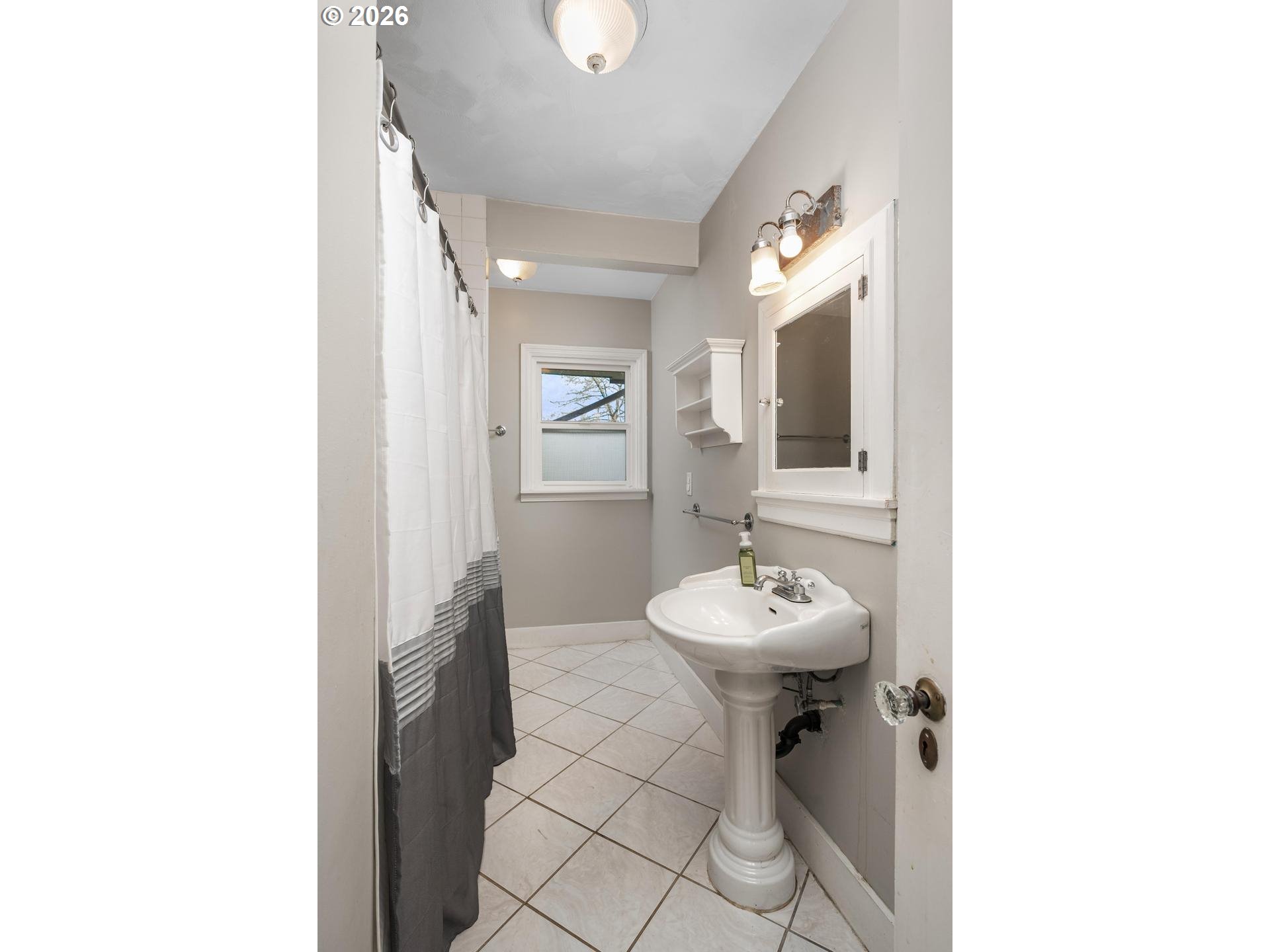3825 Northeast 63rd Avenue Portland, OR 97213 - Photo 20 of 43 a bathroom with a sink a mirror and a shower