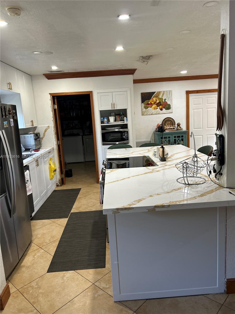2600 Southwest 126th Avenue Miami, FL 33175 - Photo 7 of 23 a kitchen with kitchen island stainless steel appliances a sink stove and refrigerator