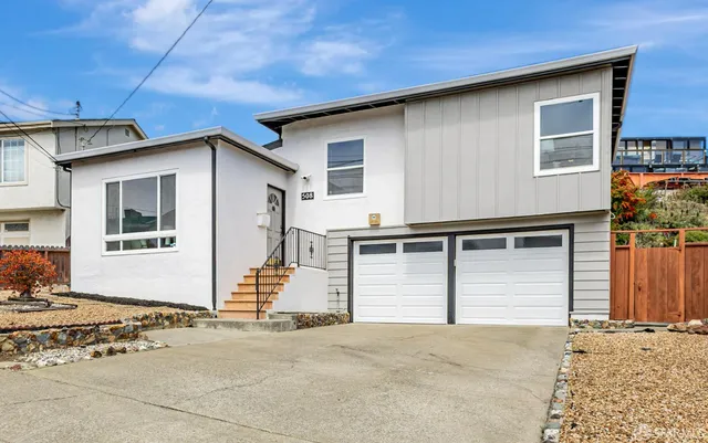 a front view of a house with a road