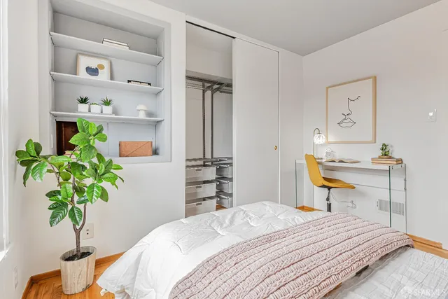 a bedroom with a bed and a potted plant