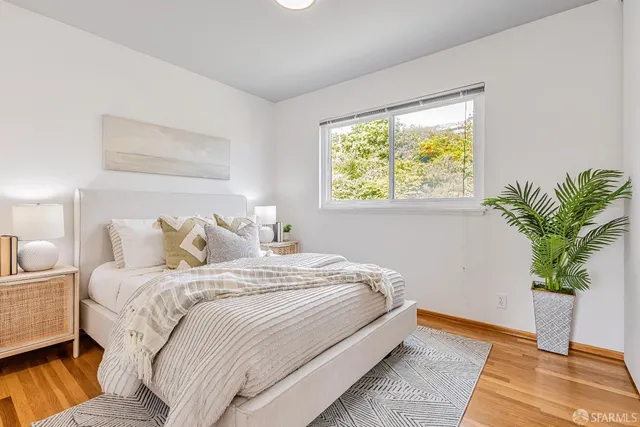 a bedroom with bed and a potted plant