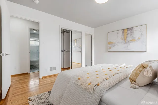 a bedroom with a bed and wooden floor