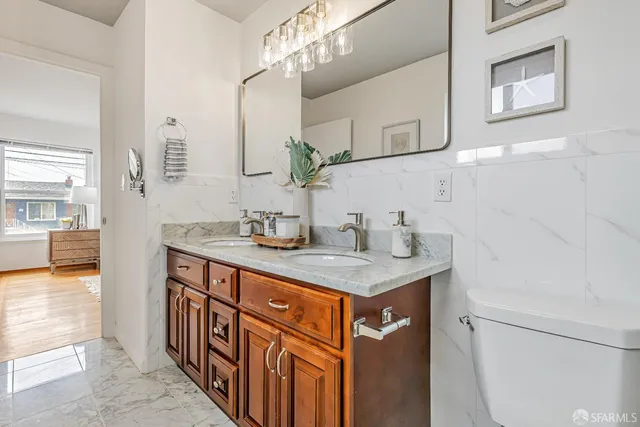 a bathroom with a sink a toilet and a mirror