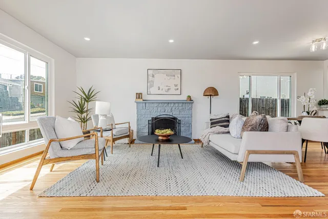 a living room with furniture a large window and a fireplace