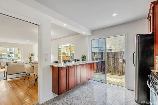 a kitchen with stainless steel appliances kitchen island granite countertop a refrigerator and a sink