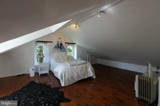 a bedroom with a bed window and wooden floor