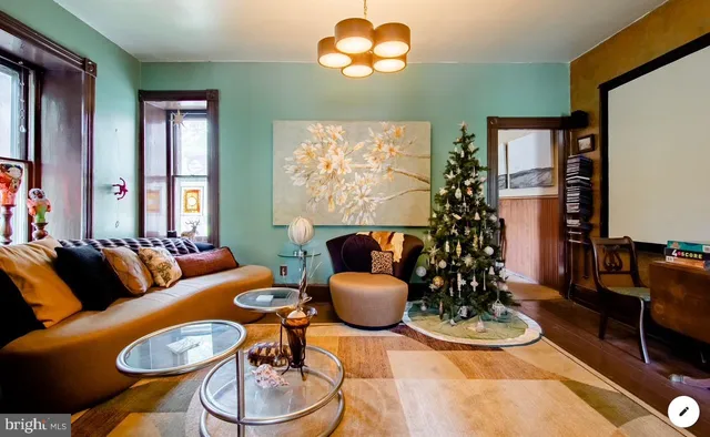 a living room with furniture a chandelier and a large mirror