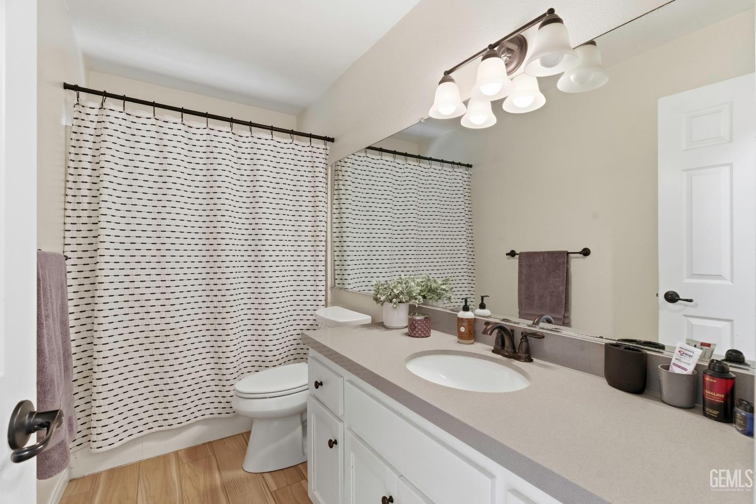 Undisclosed Address Tehachapi, CA 93561 - Photo 23 of 40 a bathroom with a toilet a sink a mirror and shower curtain
