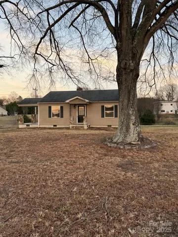 a white house that has a tree in front of it