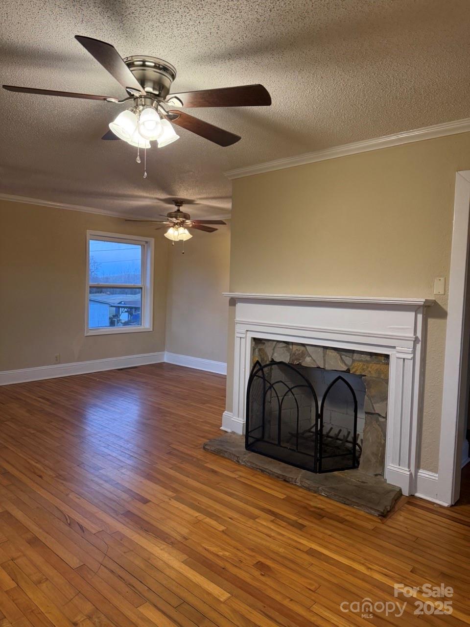 226 Shepherd Road Mooresville, NC 28115 - Photo 2 of 17 a view of a livingroom with wooden floor a ceiling fan and a fireplace