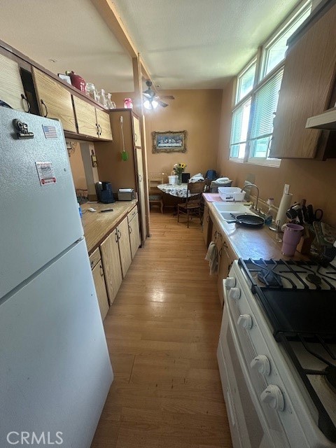 1815 West 9th Street Pomona, CA 91766 - Photo 5 of 12 a kitchen with a stove a refrigerator and a sink
