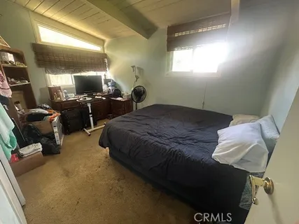a bedroom with a bed and flat screen tv