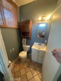 a white toilet sitting next to a bathroom sink and a mirror