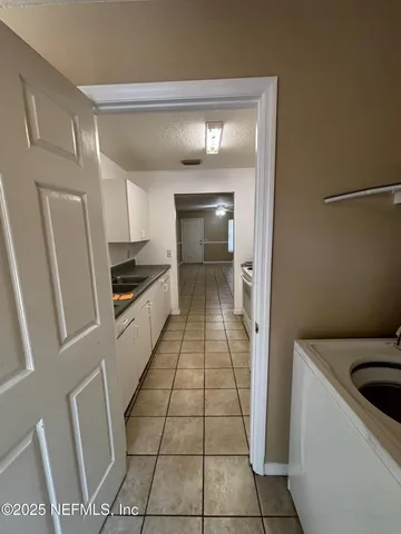 a kitchen with a sink a refrigerator and cabinets