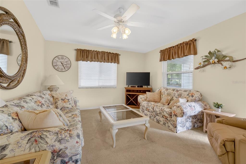 6032 Southwest 103rd Loop Ocala, FL 34476 - Photo 8 of 28 a living room with furniture a flat screen tv and a window