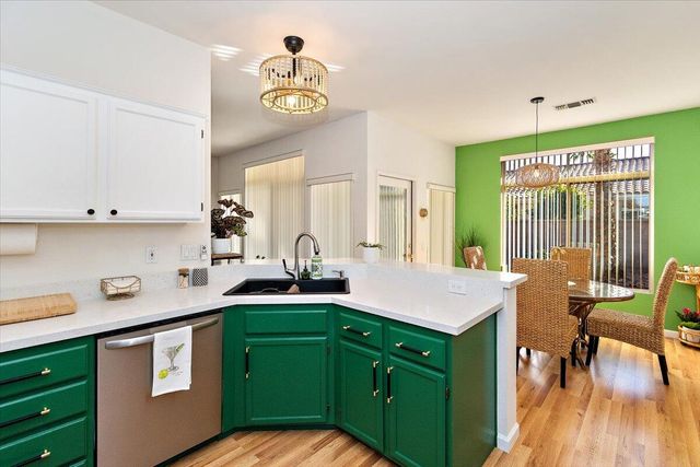 a kitchen with a sink cabinets and wooden floor