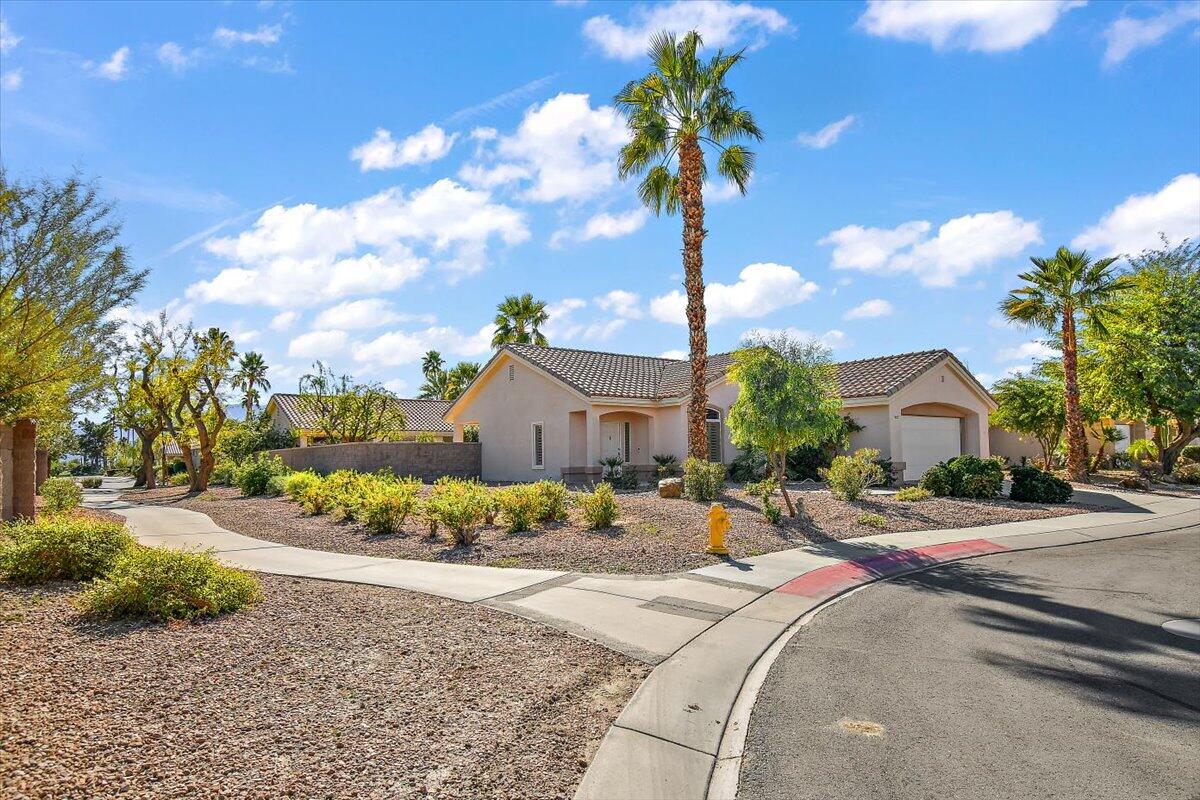 78995 Champagne Lane Palm Desert, CA 92211 - Photo 2 of 26 a front view of a house with a yard and mountain view