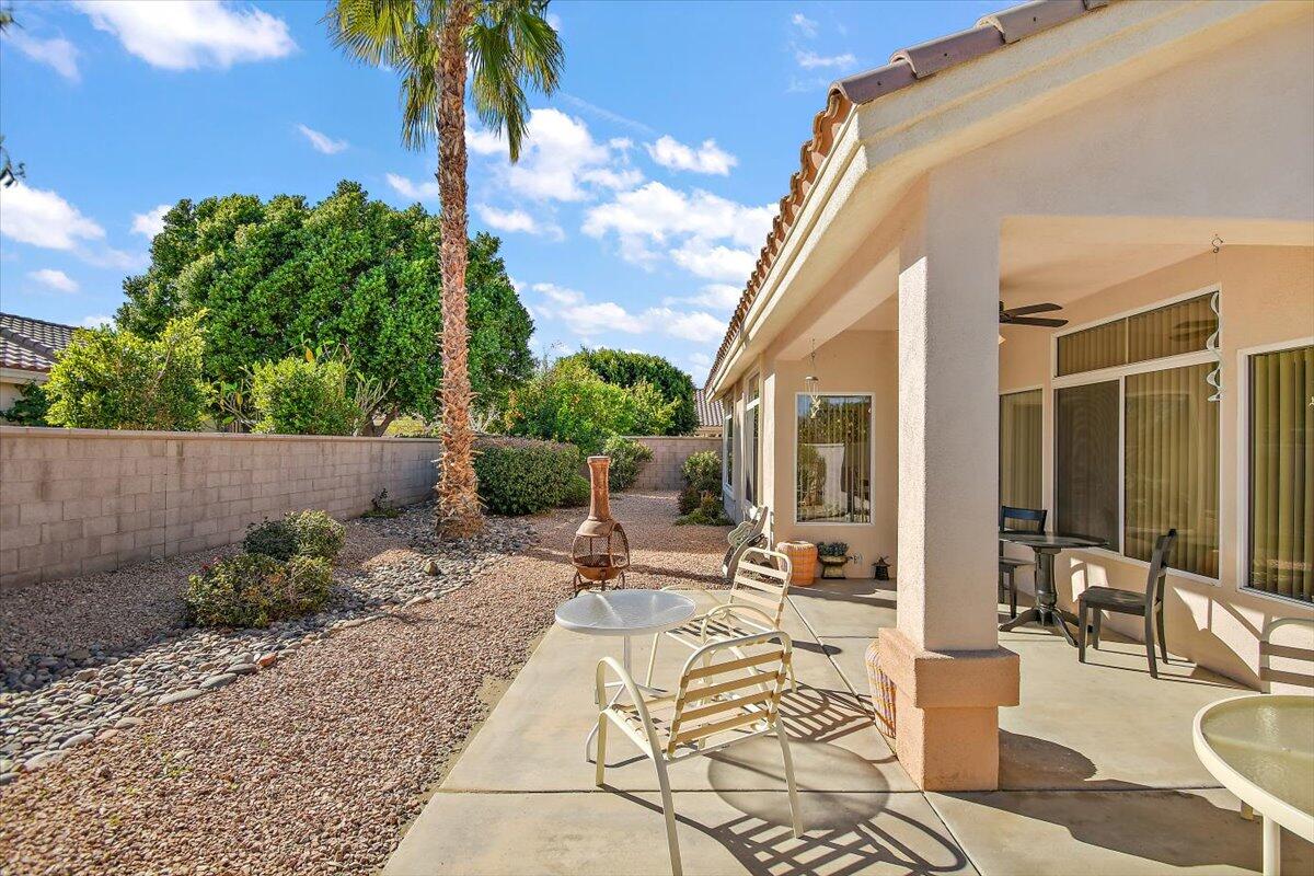 78995 Champagne Lane Palm Desert, CA 92211 - Photo 25 of 26 a view of a patio with chairs and potted plants