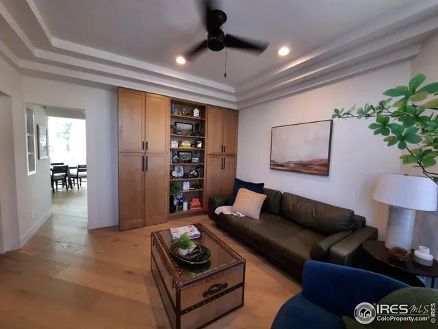 a living room with furniture floor to ceiling window and wooden floor