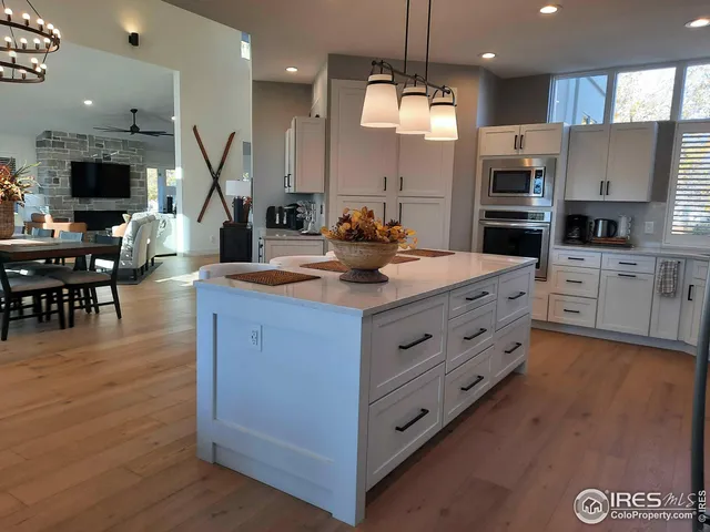 a kitchen with kitchen island granite countertop a stove oven and a view of living room