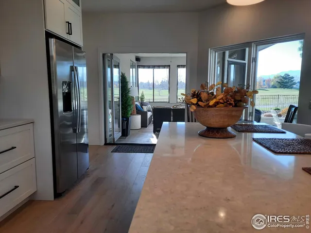 a living room with furniture floor to ceiling window and wooden floor