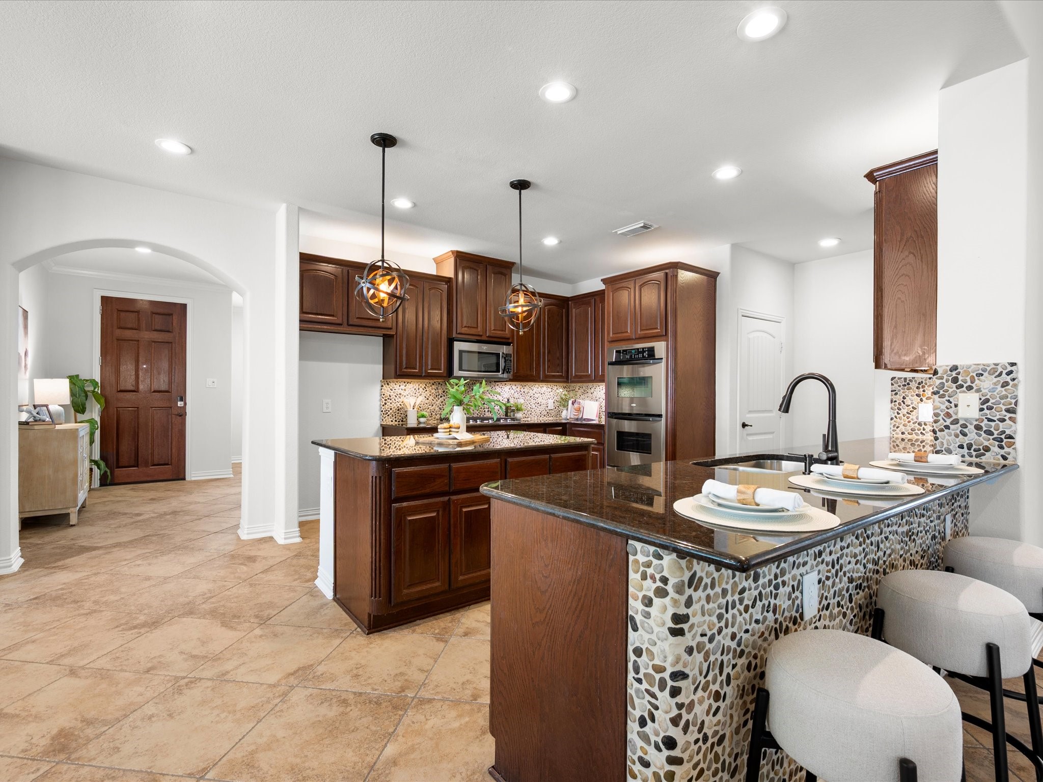 323 Arbor Ridge Lane Conroe, TX 77384 - Photo 11 of 40 Pull up a stool. Morning coffee, homework, happy hour, this bar does it all. The pebble tile detail is the kind of thing you don't find in new builds.