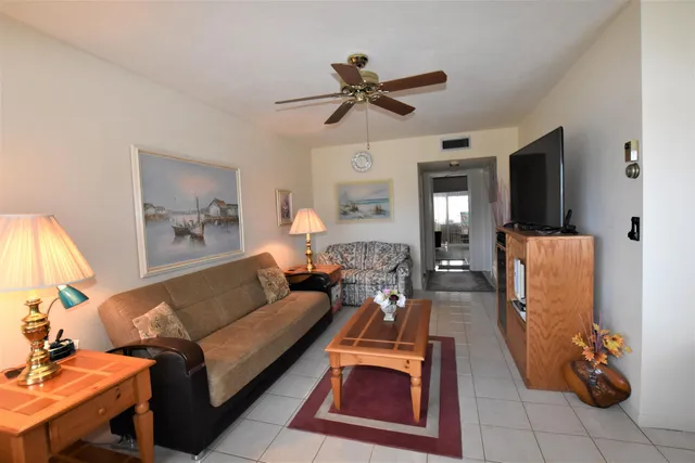 a living room with furniture a flat screen tv and a lamp